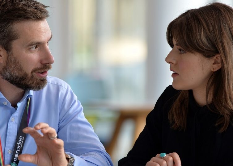 2 people discussing information on a tablet