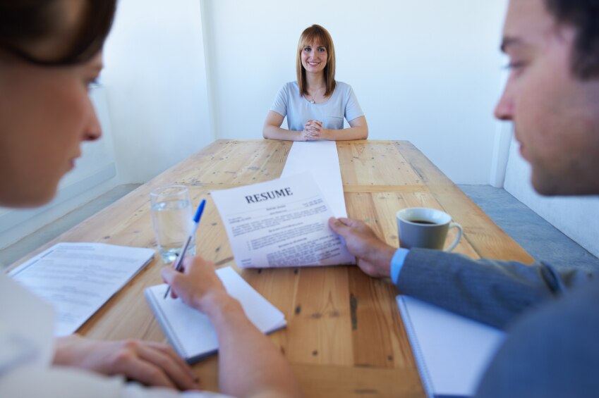 Girl sitting across the table from two people reviewing her resume