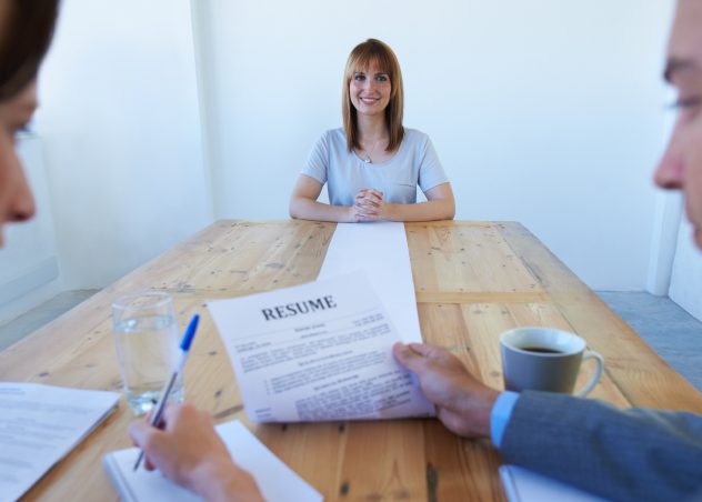 Girl sitting across the table from two people reviewing her resume