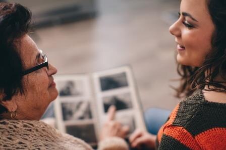 Girl looking at a photo album with her grandma