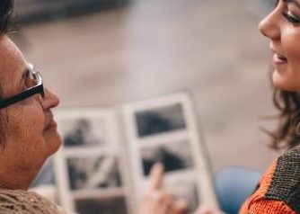 Girl looking at a photo album with her grandma