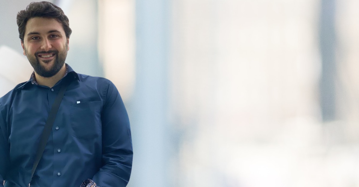 Man in dark blue dress shirt with blurred background