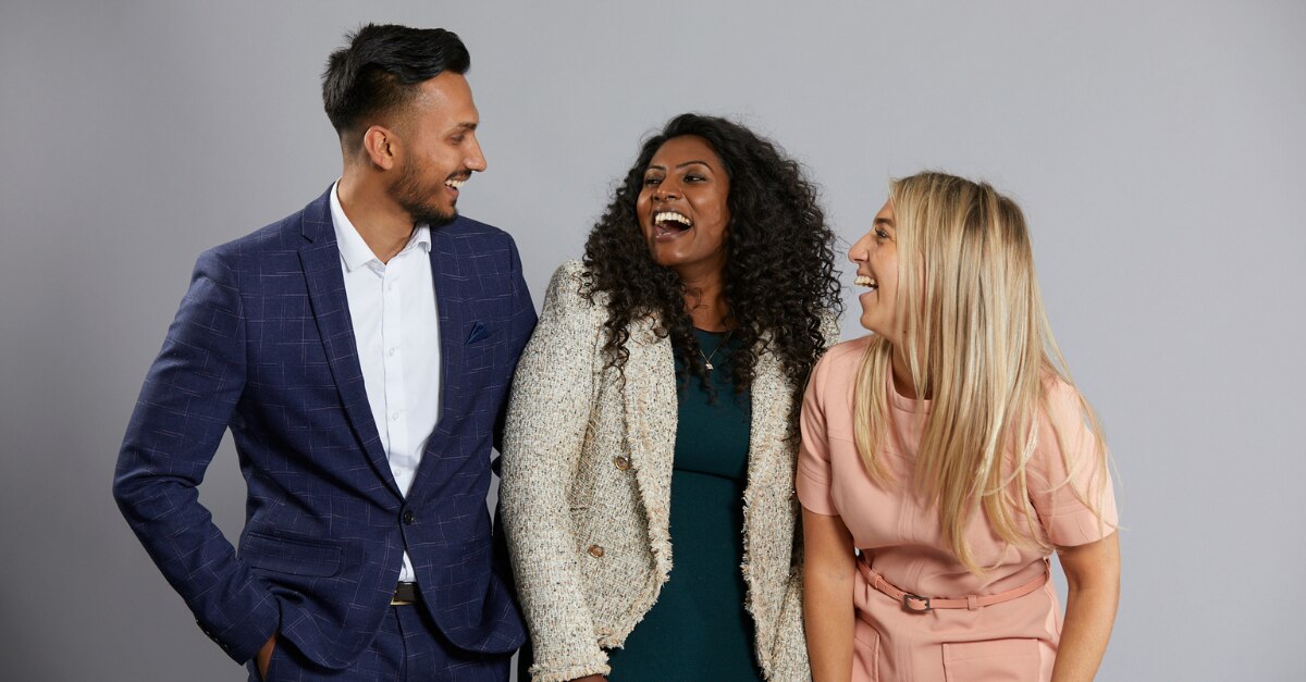 Three people smiling at each other