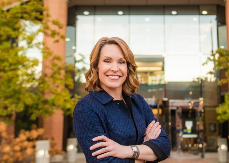 Photo of CEO Chrissy Taylor in front of brick and glass building