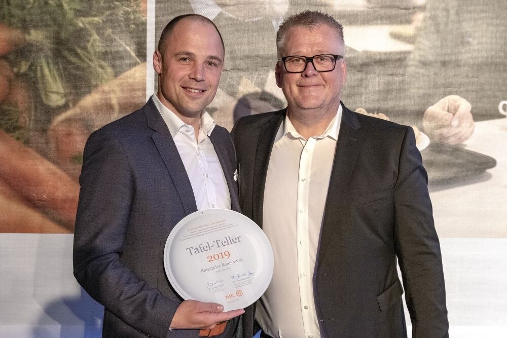 Two men holding an award