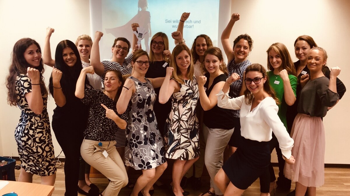 Group of women in business attire flexing their biceps 