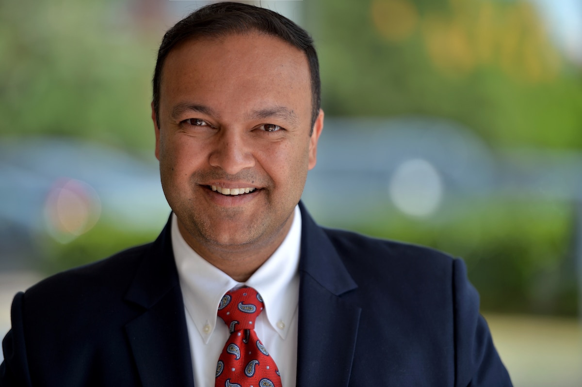 Photo of man in suit with a red tie with blurred background