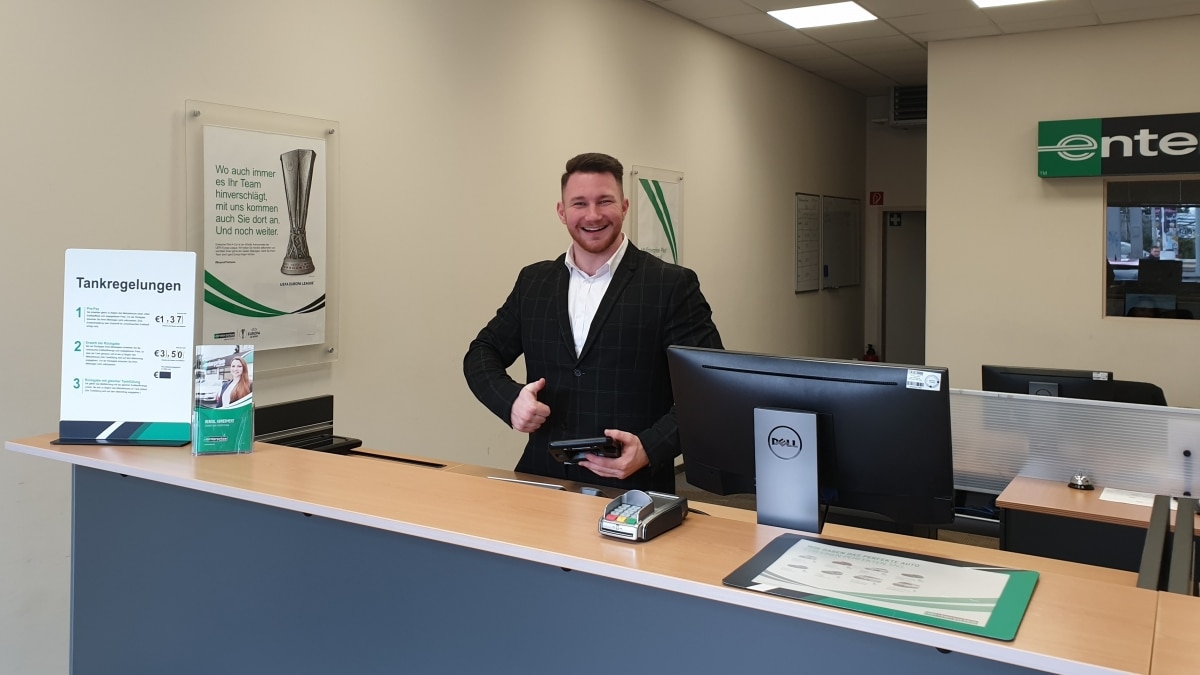 Man behind Enterprise service counter giving a thumbs up