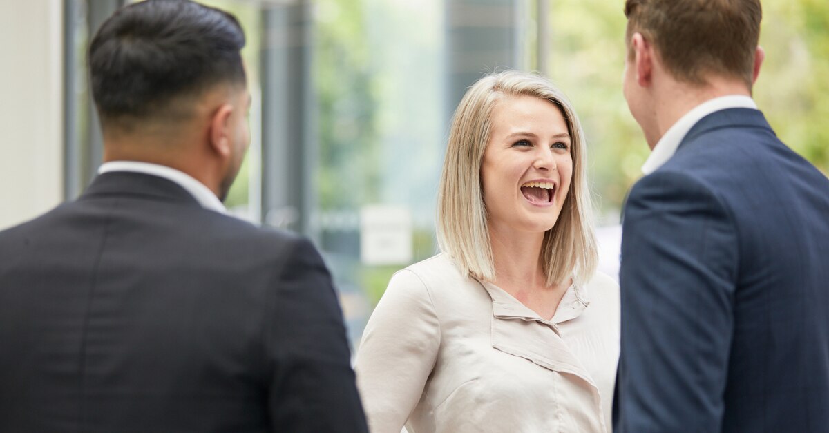 Woman smiling at two men in suits