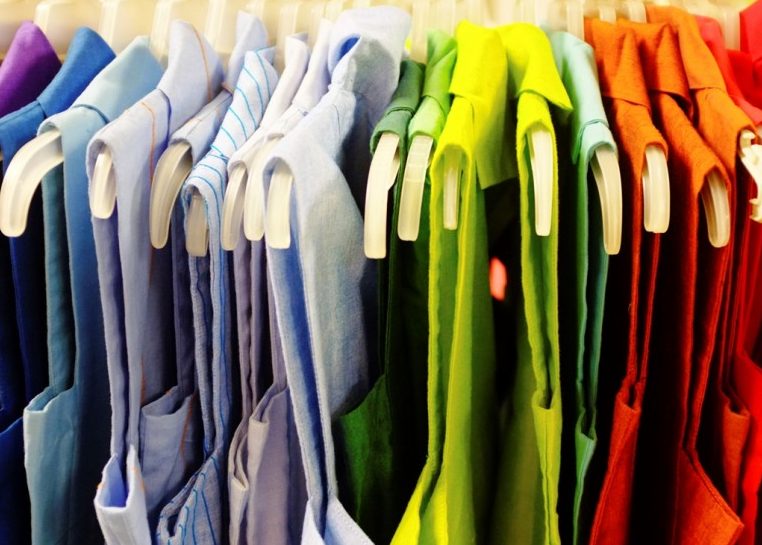 Sleeveless blouses hung in rainbow order