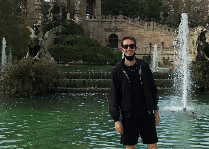 Photo of man standing in front of a fountain and smiling
