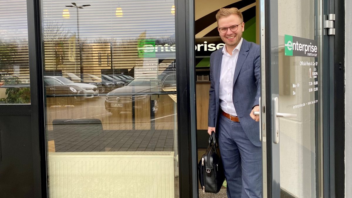 Man in suit with briefcase walking out of Enterprise office