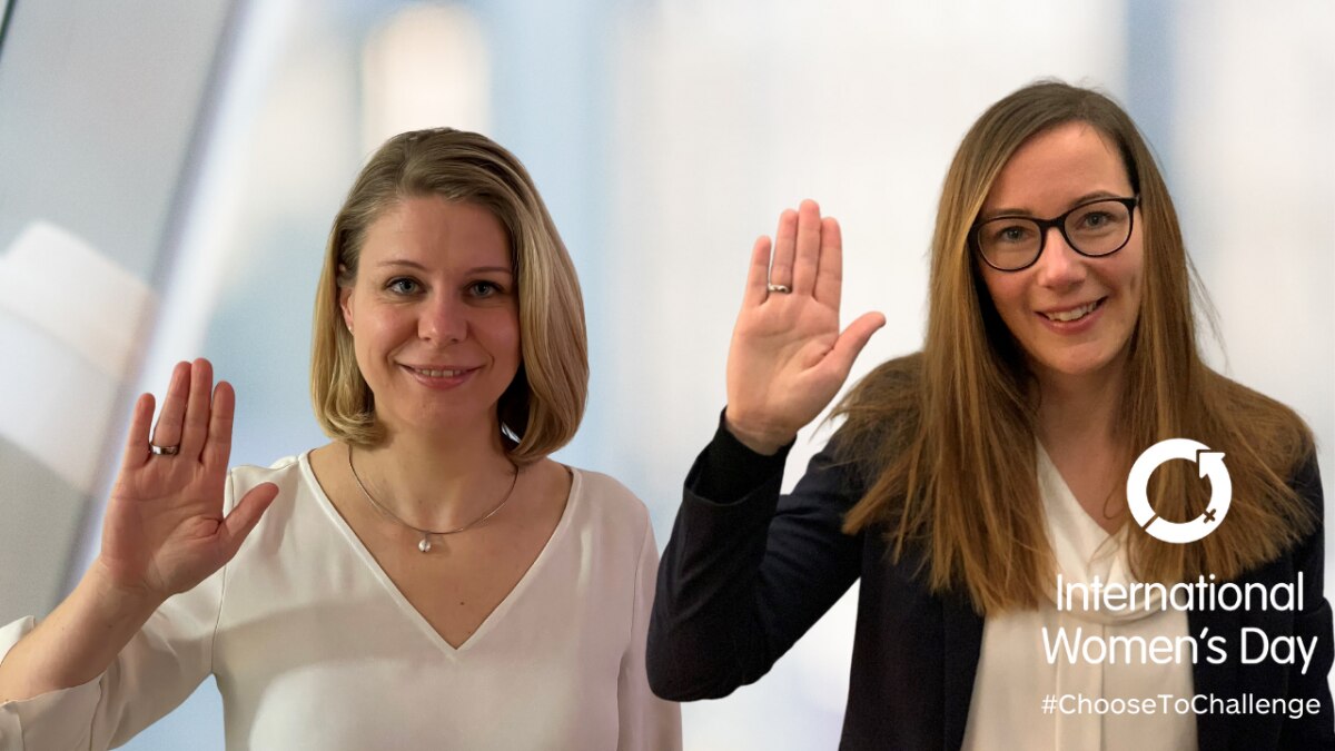 Two women raising their right hands