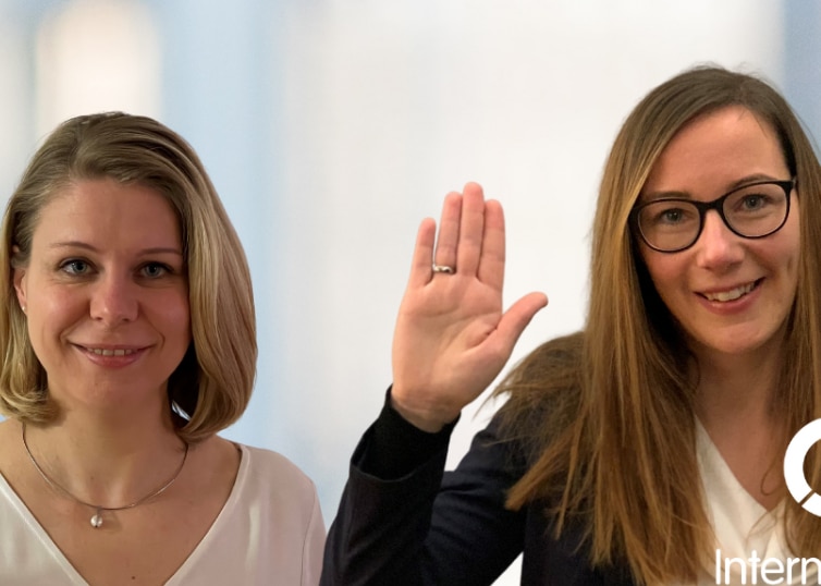 Two women raising their right hands