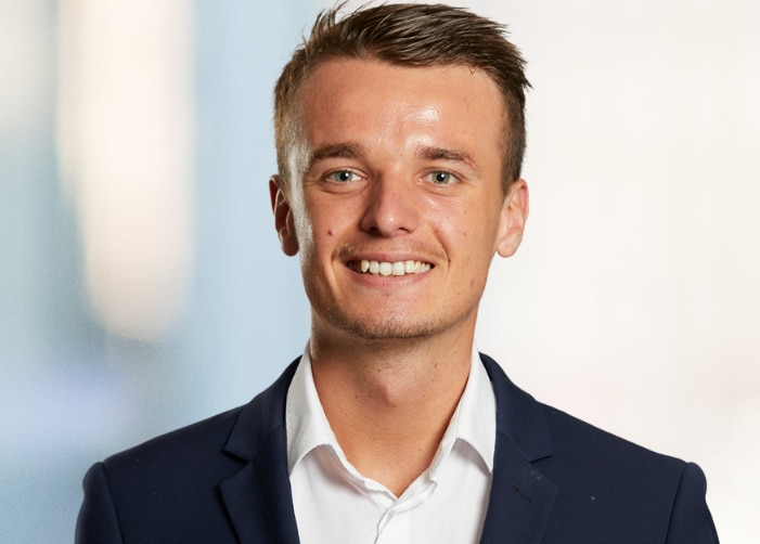 Man in suit smiling with a blurred background