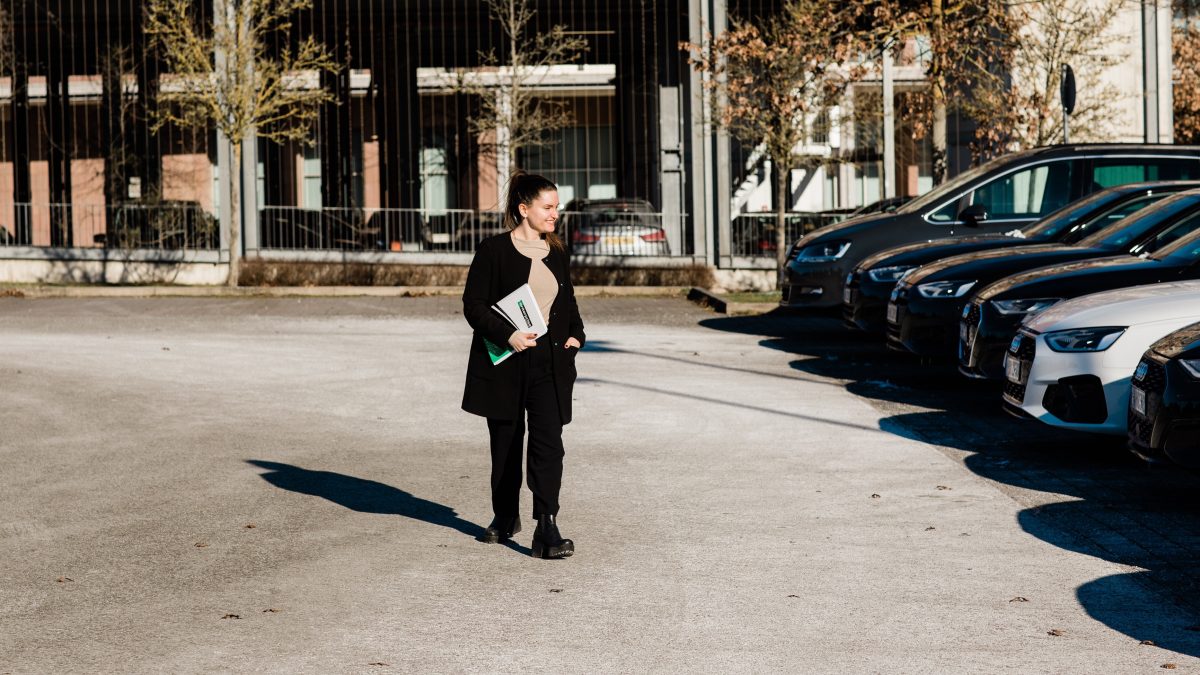 Girl holding Enterprise folder and walking through parking lot