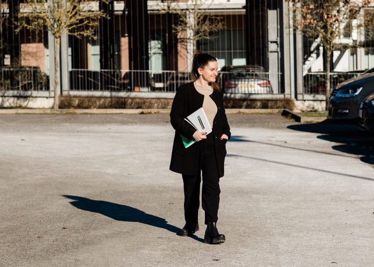 Girl holding Enterprise folder and walking through parking lot