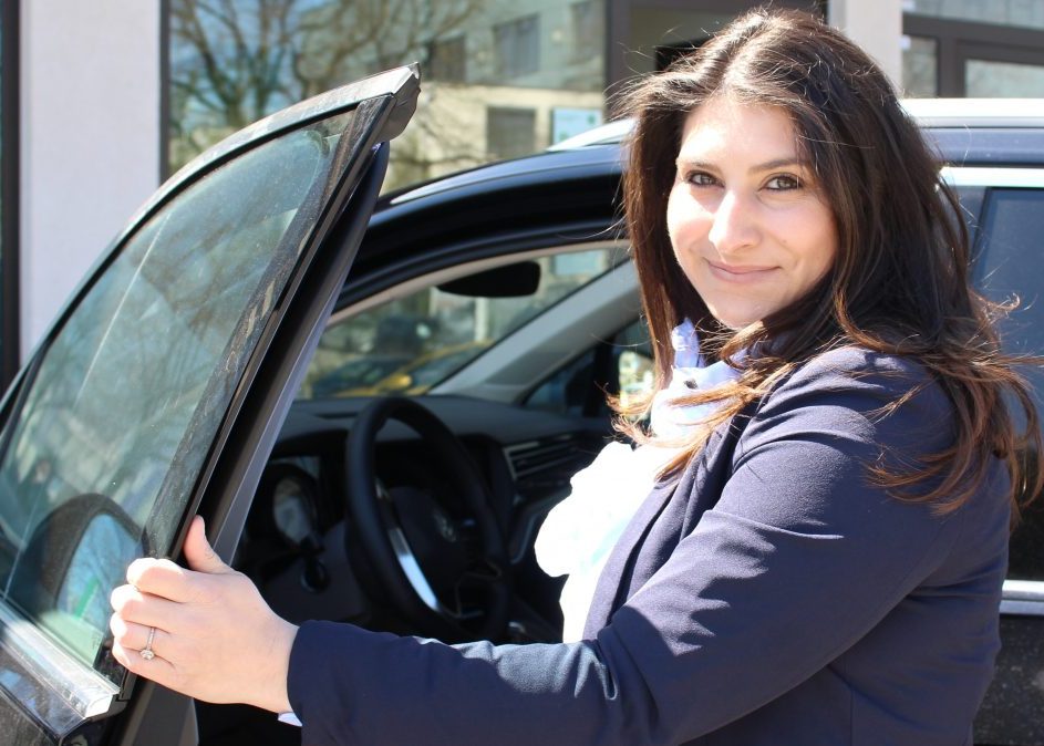 Woman opening car door and smiling