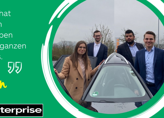 Four interns in professional dress standing around a car with a quote on a green background