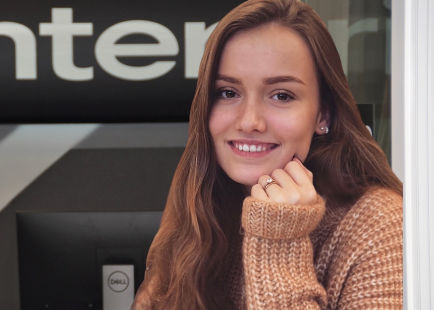 Photo of a girl in a sweater in front of Enterprise sign