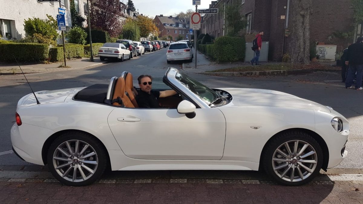 Man driving a white convertible