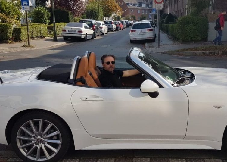 Man driving a white convertible