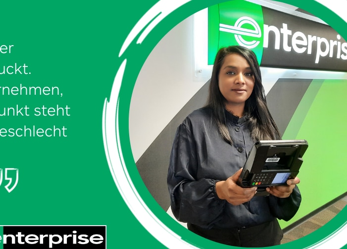 Woman in black shirt holding card reader machine in front of Enterprise sign with a quote on a green background