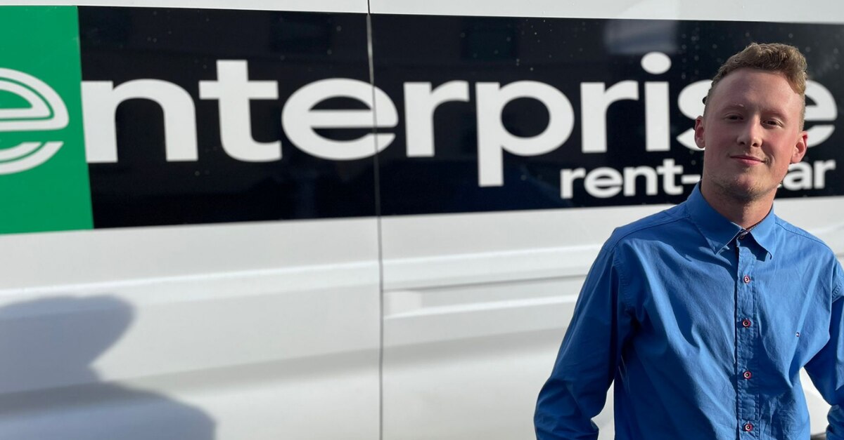 Man standing in front of van with Enterprise logo on it