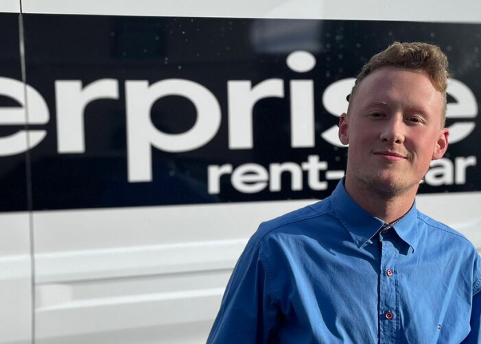 Man standing in front of van with Enterprise logo on it