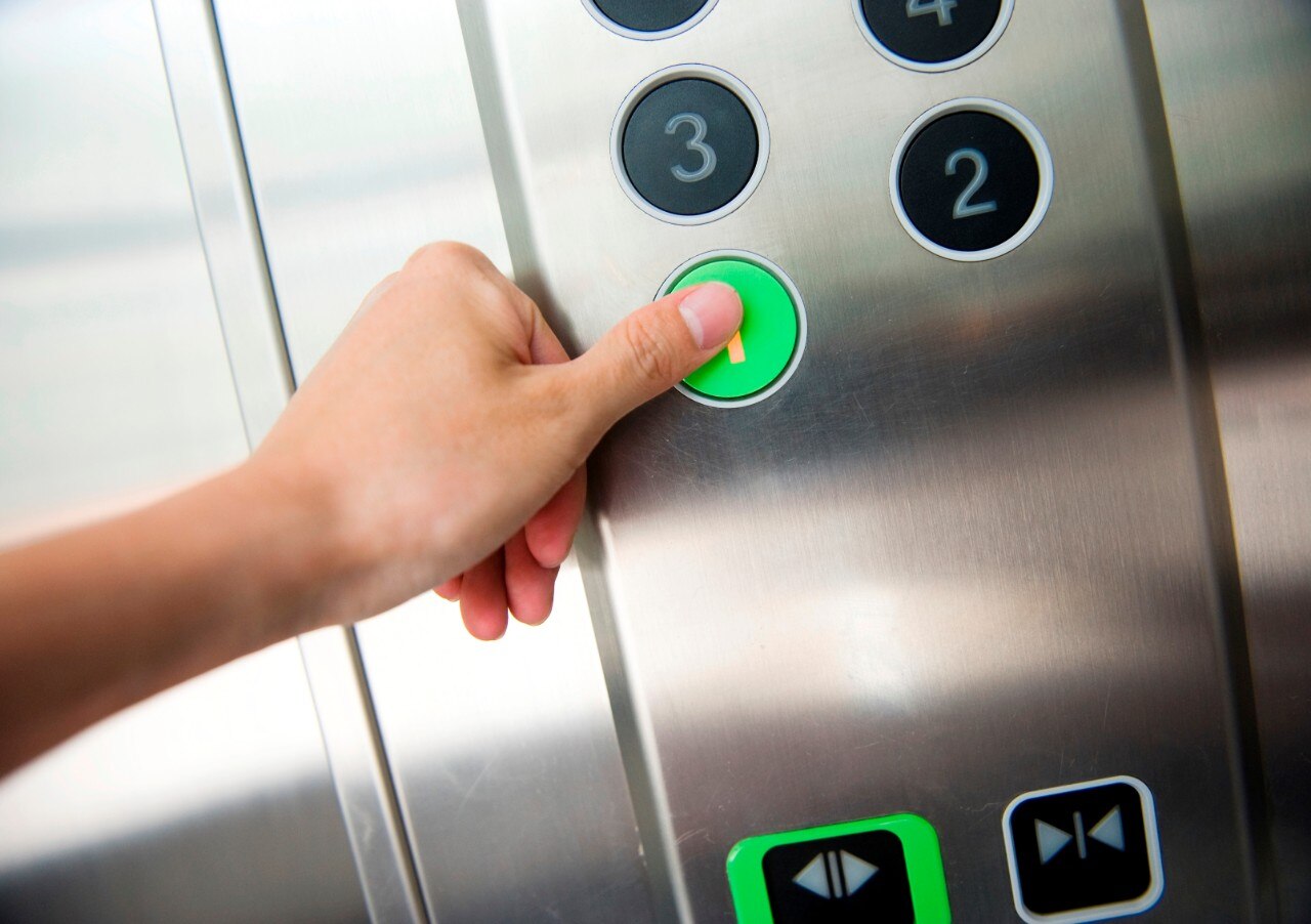 Thumb pressing floor 1 button in an elevator