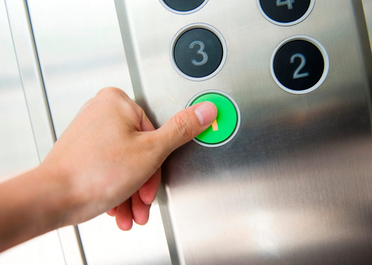 Thumb pressing floor 1 button in an elevator