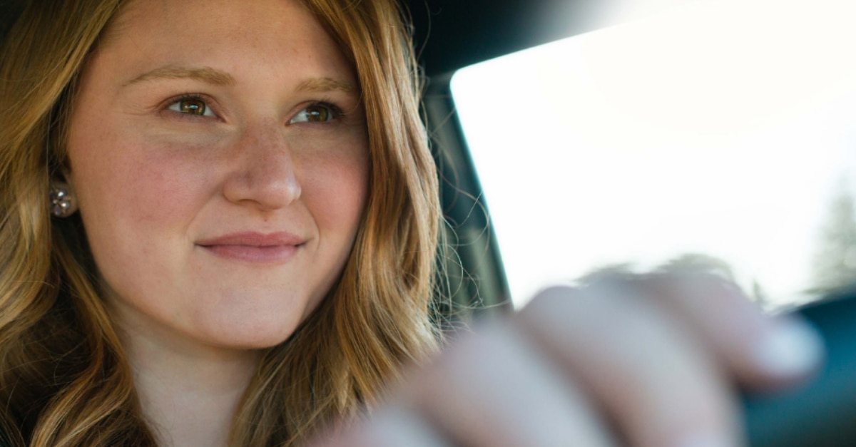 Girl with a soft smile driving a car