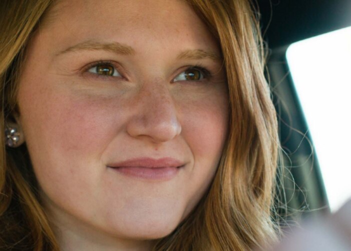 Girl with a soft smile driving a car