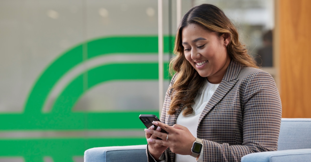 Ein Mitglied des Enterprise-Mobility-Teams schaut auf ihr Handy und verbessert ihr LinkedIn-Profil