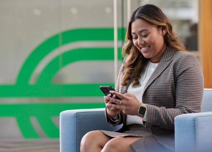 Ein Mitglied des Enterprise-Mobility-Teams schaut auf ihr Handy und verbessert ihr LinkedIn-Profil