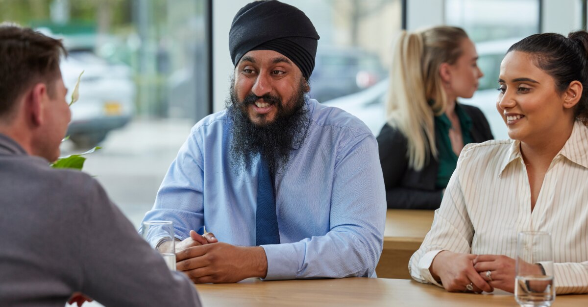 Drei Teammitglieder von Enterprise Mobility sitzen zusammen an einem Tisch