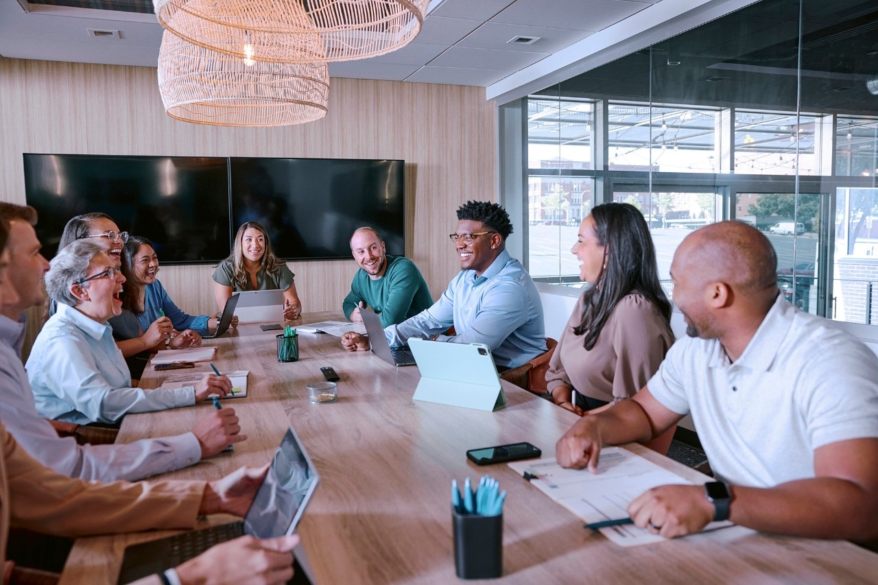 Enterprise Mobility team member standing at the front of a long table presenting to colleagues around the table 